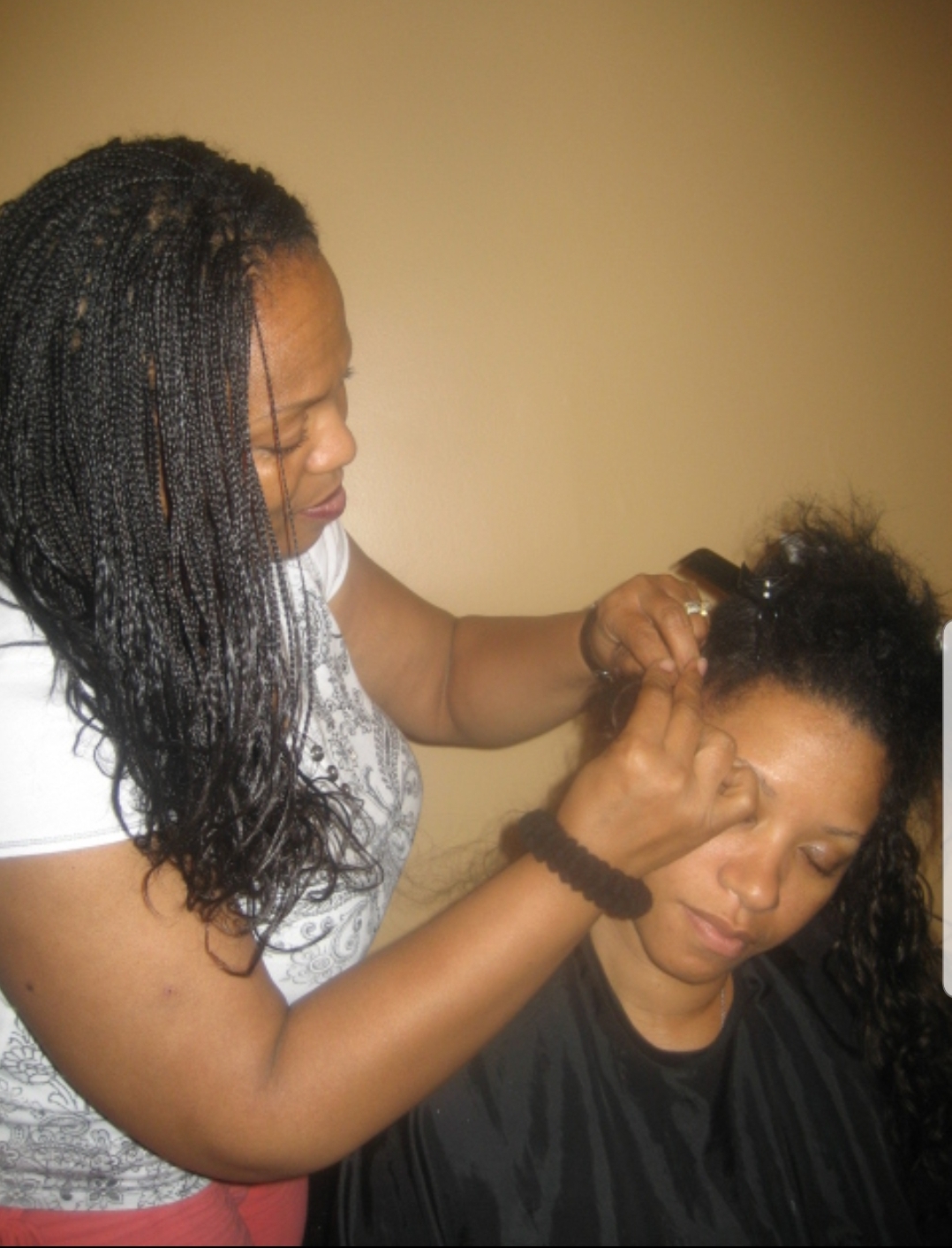 Master stylist Priscilla braiding a client at Angel Hair Braids